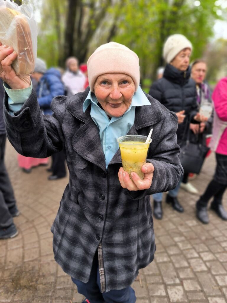 Ukraine outreach-elderly women receives sandwich and soup.