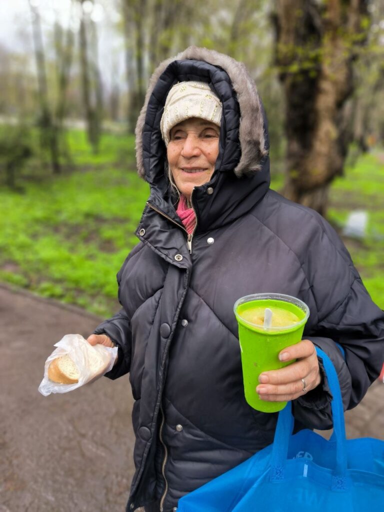 Ukraine outreach-women receives sandwich and soup.