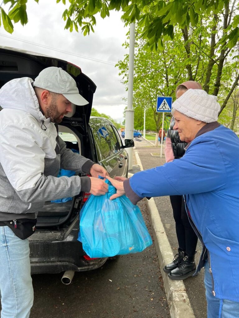 man feeding two women in Ukraine