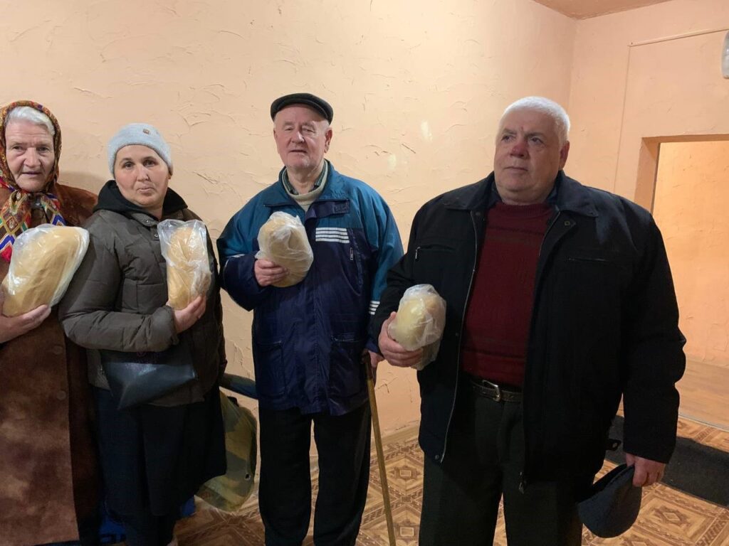 men and women receive bread in Ukraine