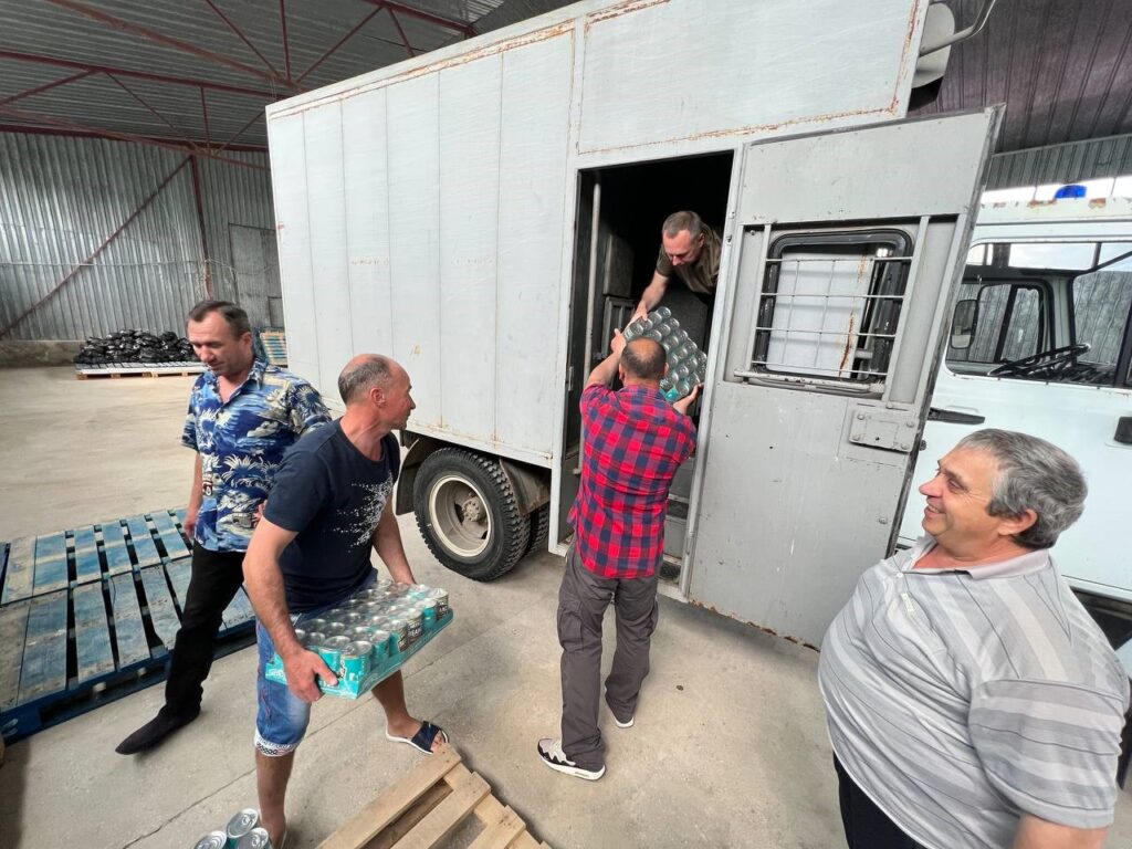 Five men unloading supplies from a truck.