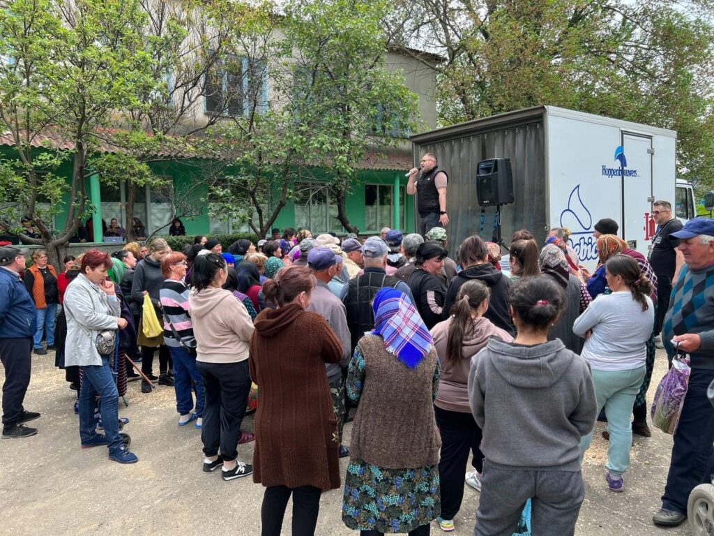 Man sharing the Gospel to a crowd of bystanders.