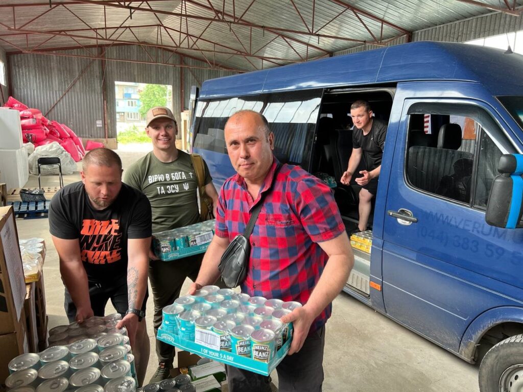Men unloading supplies from a van.