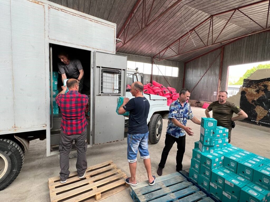 Men unloading supplies from a truck.