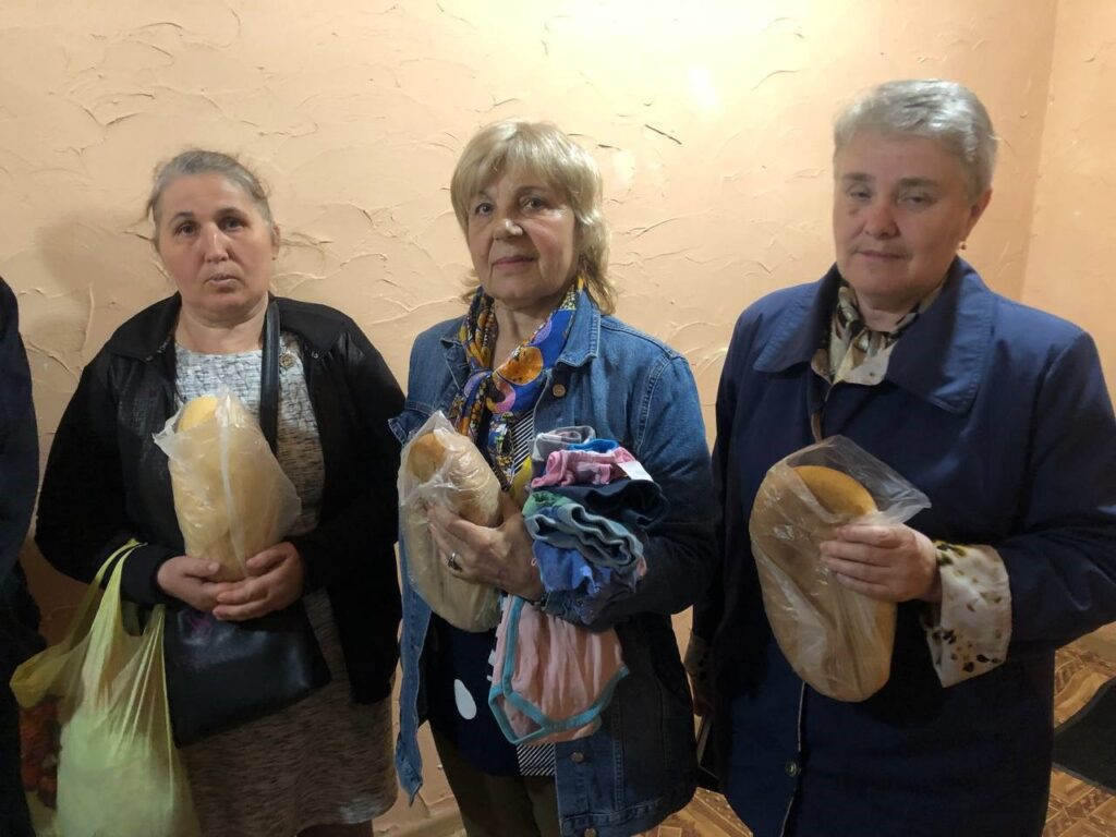 Three women receive bread.