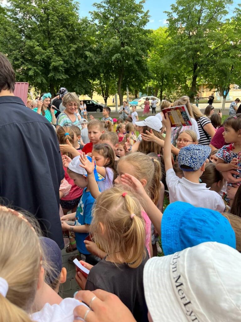 Group of children eagerly receiving children's Bibles.