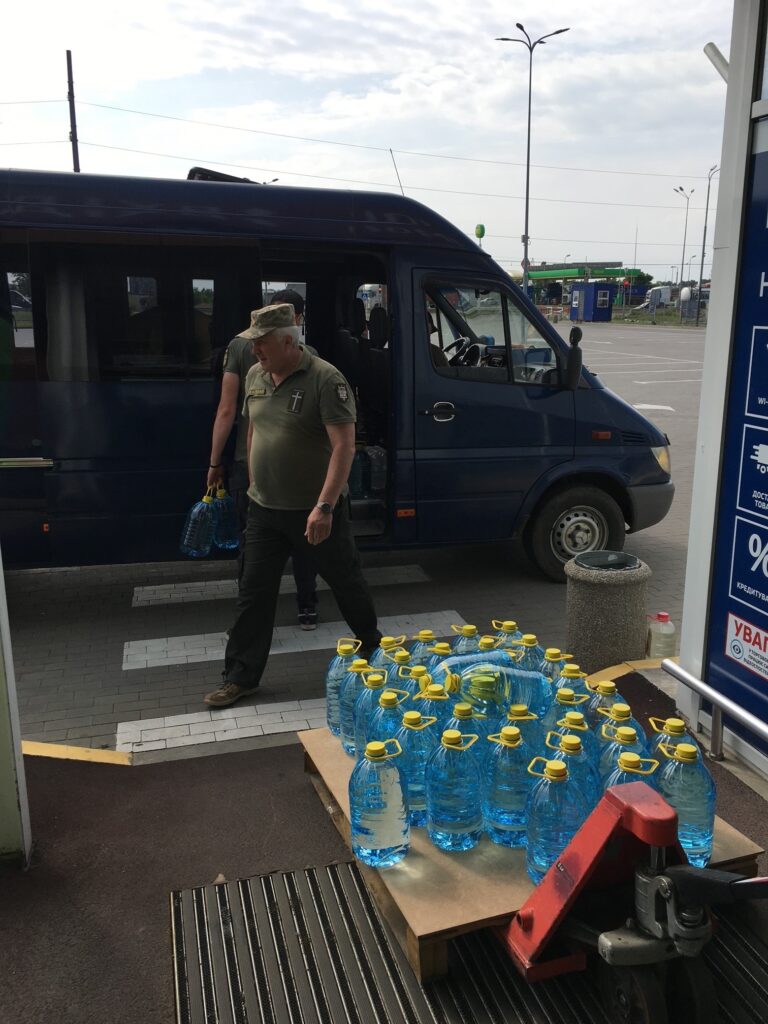 Two men loading water to deliver to needy people in Ukraine.