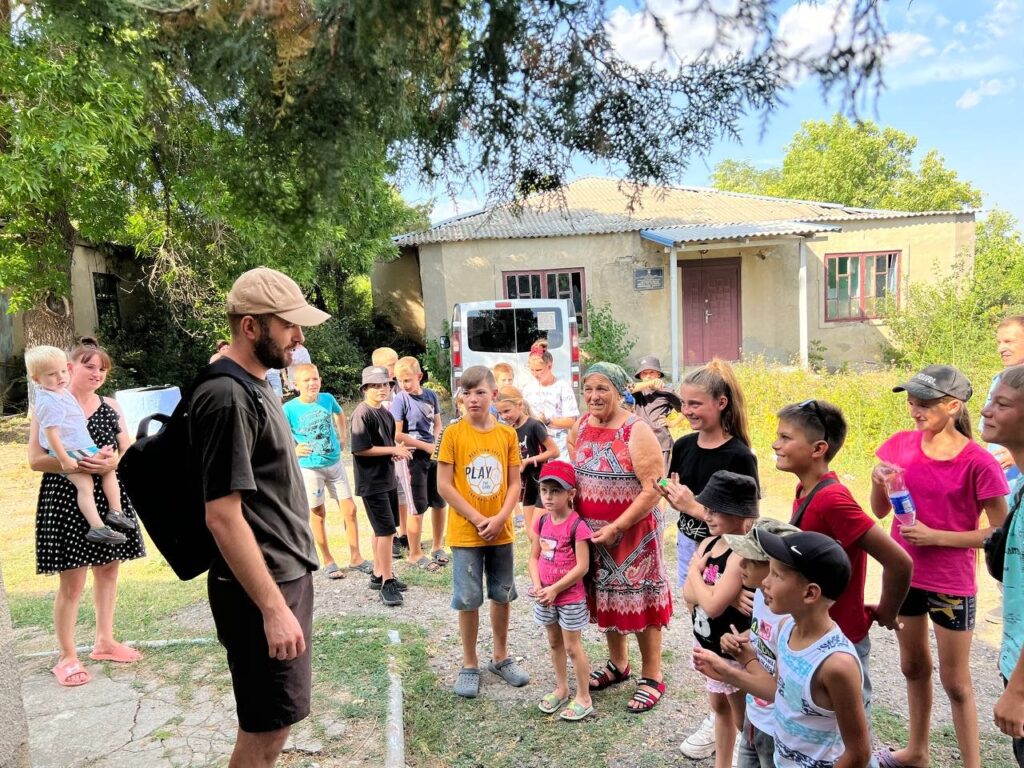 Man speaking to a group of children.