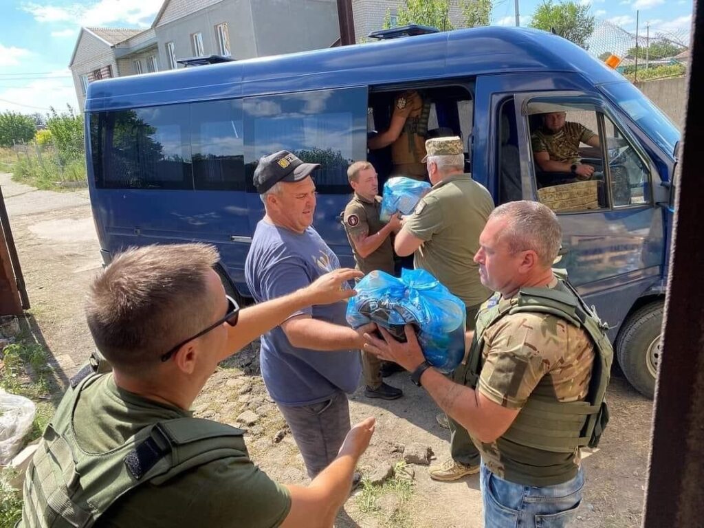 Men unloading supplies from a blue truck.