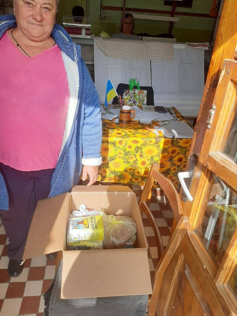 Woman next to a box with food 