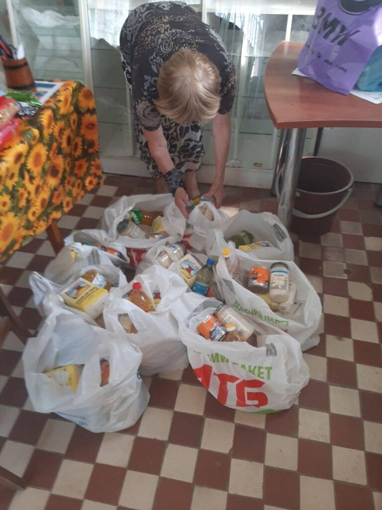 Woman putting together 9 bags with food