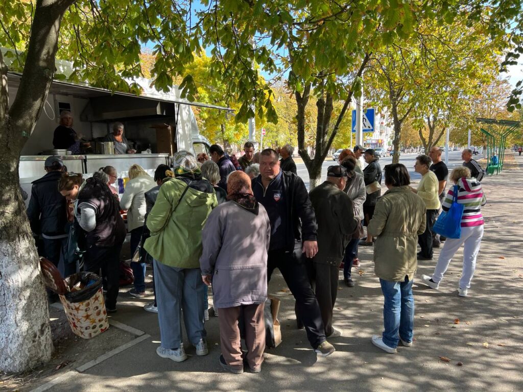 Group of people standing before a food truck