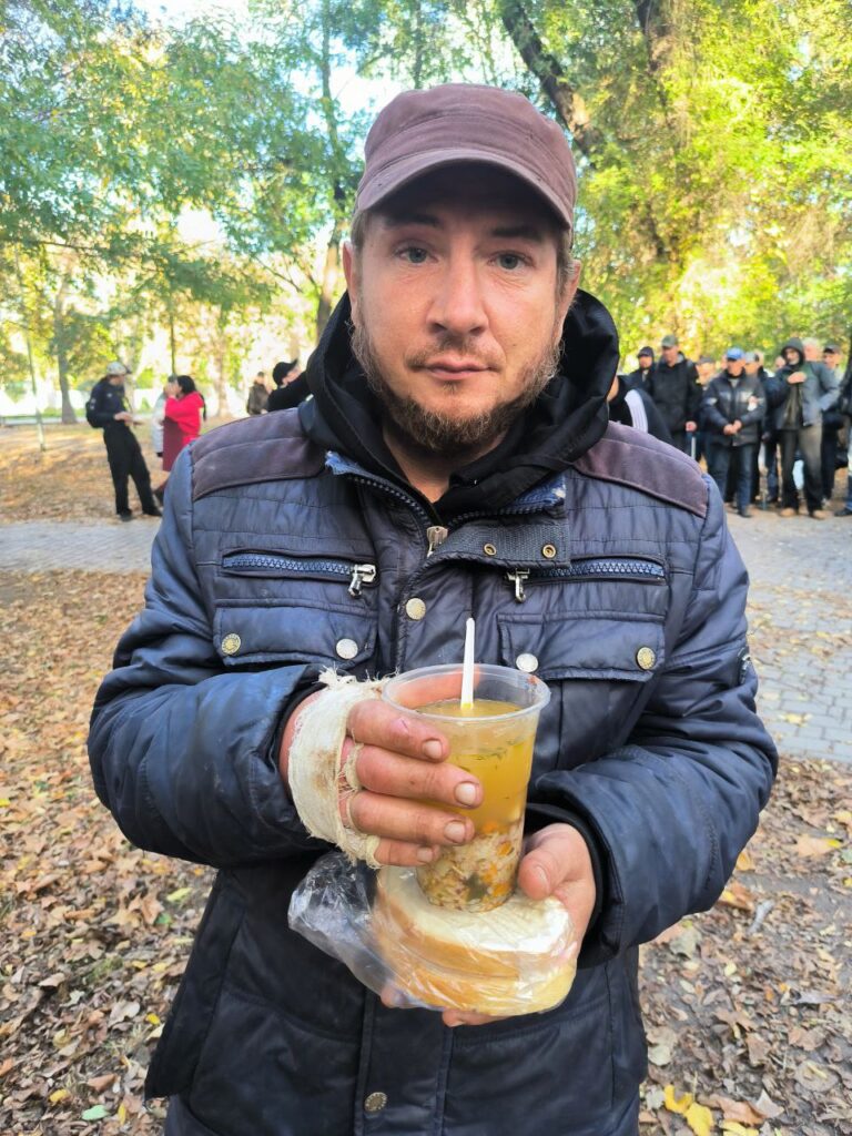 Man holding food looking at camera