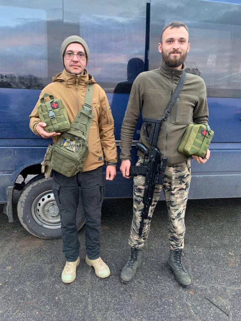Two men in military gear with first-aid kits