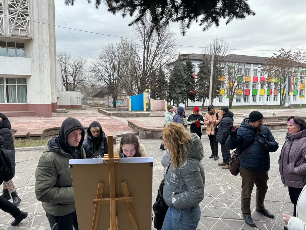Group of people looking at art outside