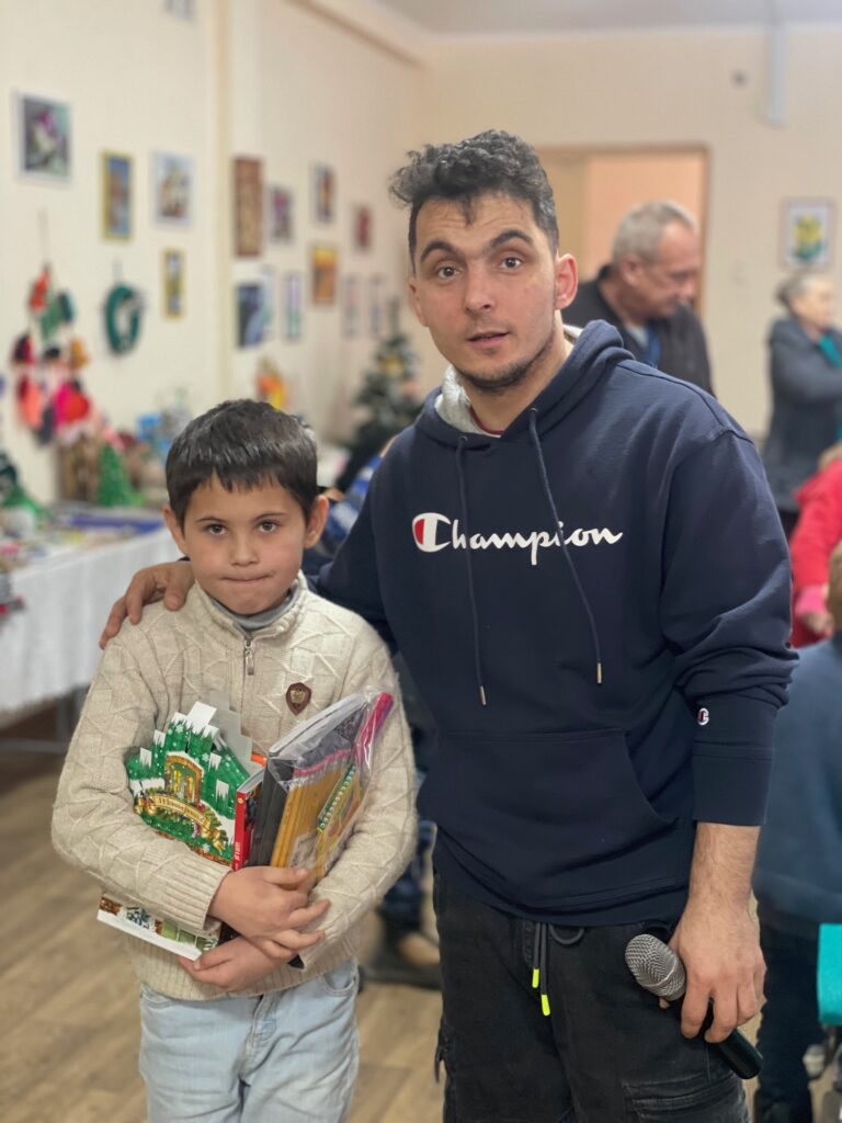 Man and young boy with gifts looking at camera