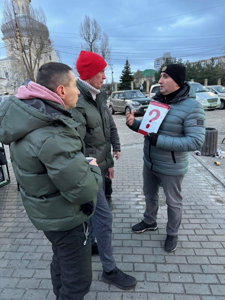 Three people talking on the street with image of red question mark