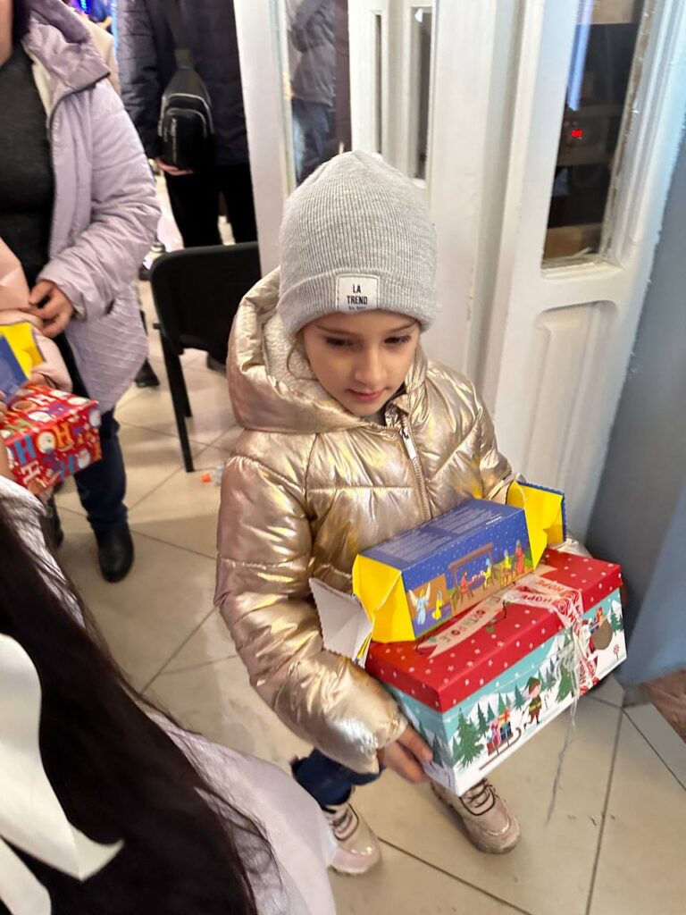 Image of young girl holding gifts from outreach