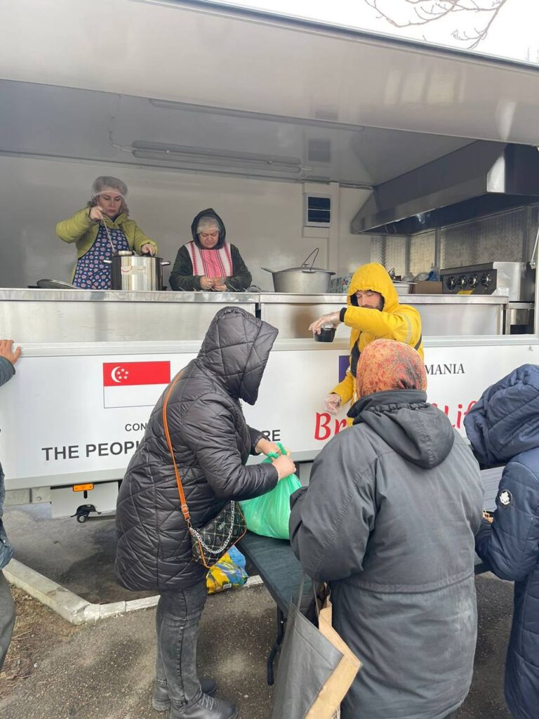 Several people outside of food truck receiving food