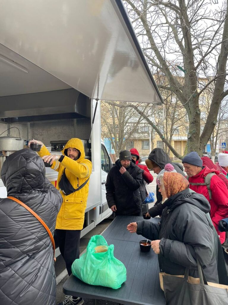 Several people outside of food truck receiving food