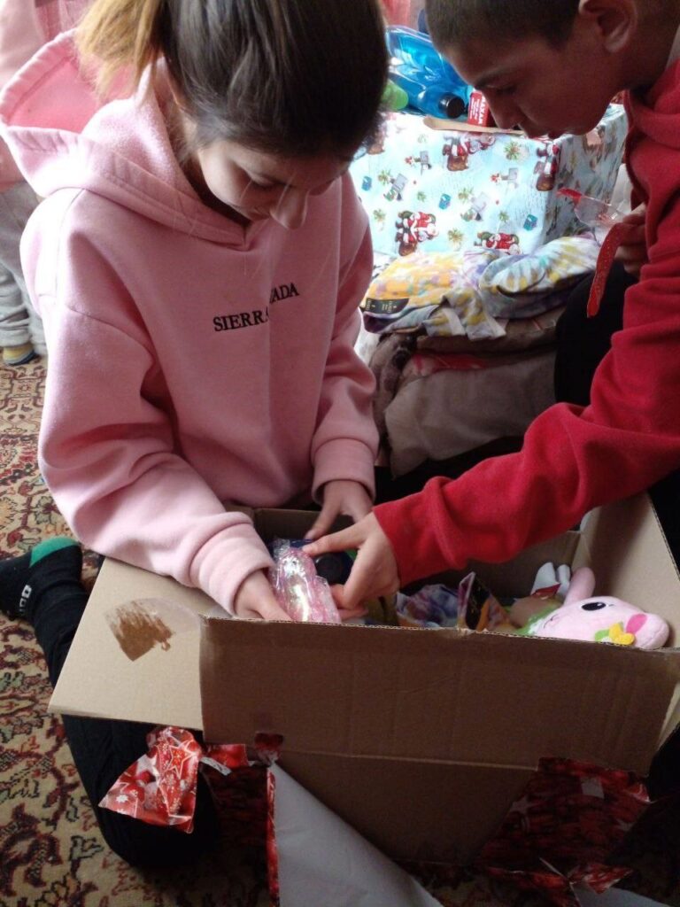 Girl and boy opening a gift.