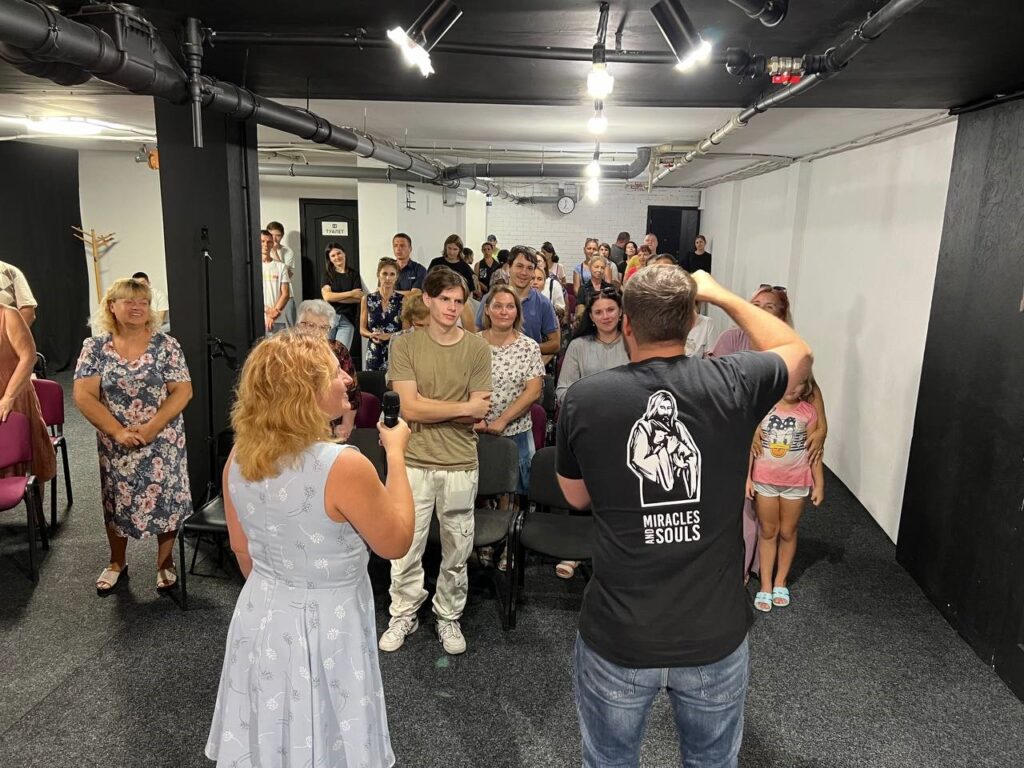 Man and woman speaking to youth inside a building